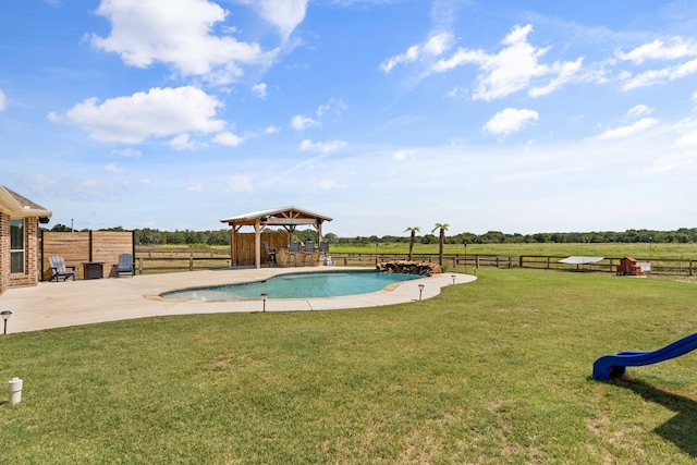 view of swimming pool with a rural view, a patio, a lawn, and a gazebo