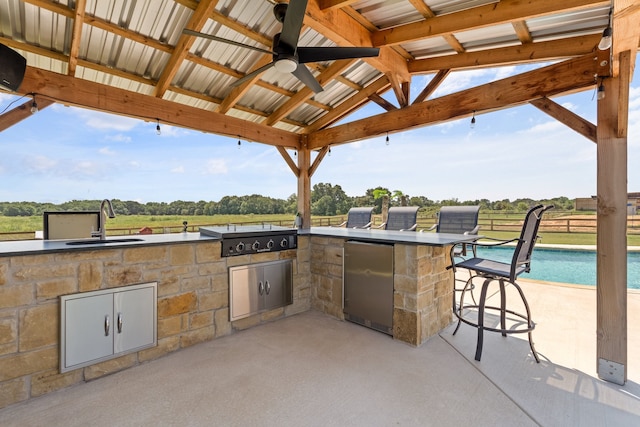 view of patio / terrace featuring a gazebo, a wet bar, ceiling fan, grilling area, and area for grilling