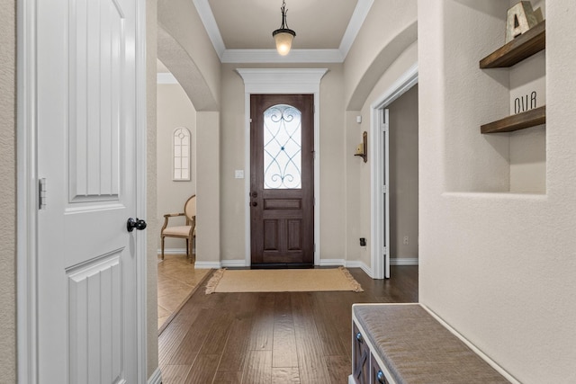 entrance foyer featuring ornamental molding and dark hardwood / wood-style floors