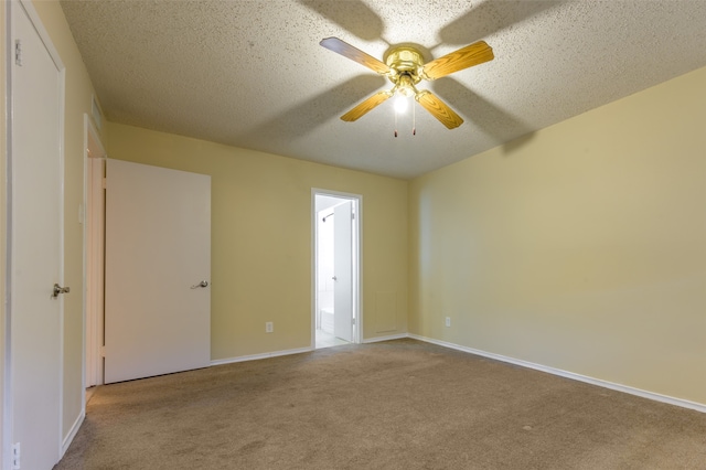 empty room with a textured ceiling, light colored carpet, and ceiling fan