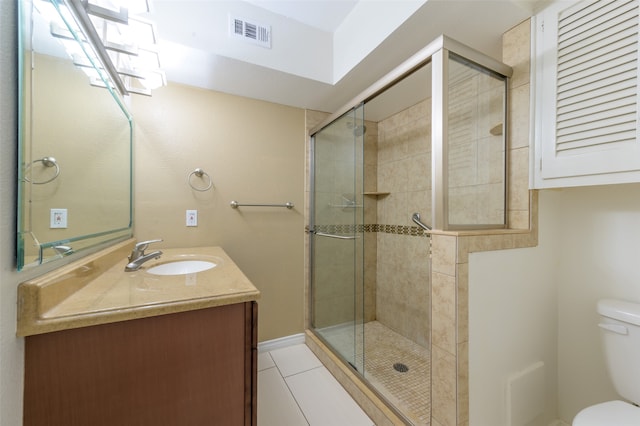 bathroom with tile patterned flooring, a shower with door, toilet, and vanity