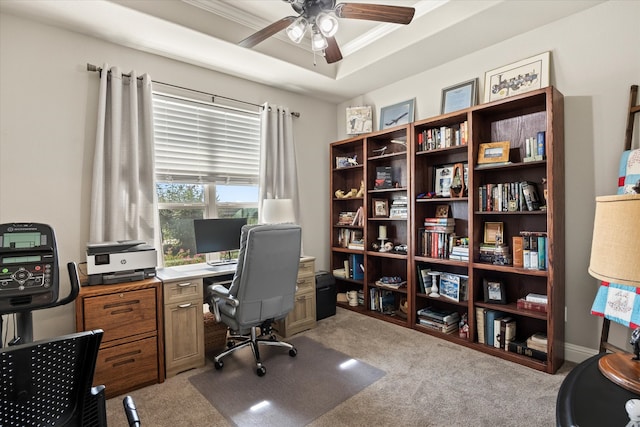 carpeted office with ornamental molding, ceiling fan, and a tray ceiling