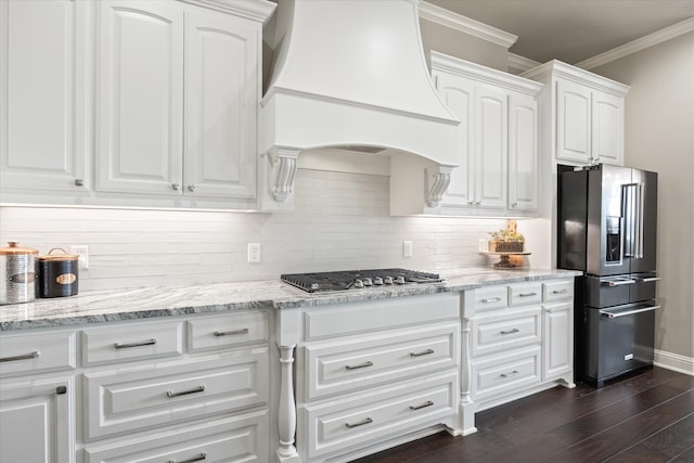 kitchen with premium range hood, white cabinets, stainless steel appliances, crown molding, and light stone countertops