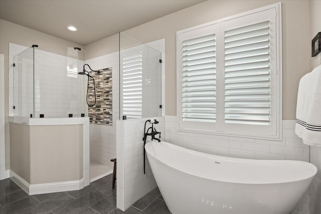 bathroom with tile patterned flooring, shower with separate bathtub, and tile walls