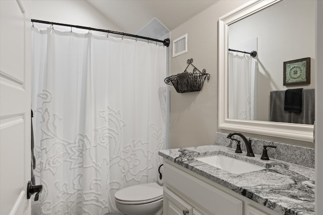 bathroom featuring vanity, toilet, and lofted ceiling