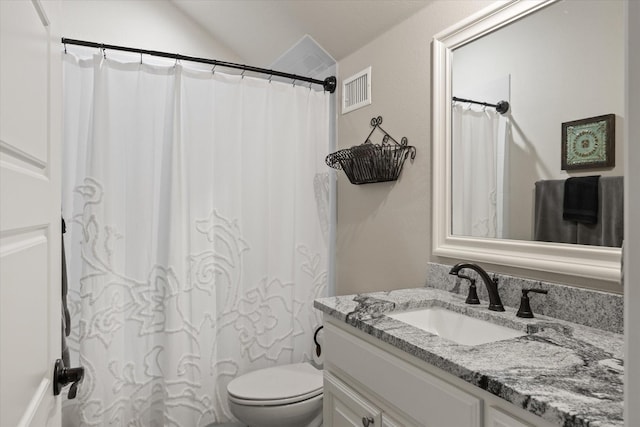 bathroom with vanity, toilet, and vaulted ceiling