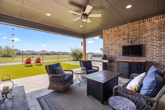 view of patio featuring ceiling fan, an outdoor living space, grilling area, and exterior kitchen