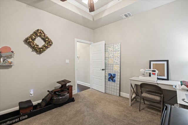 office area with ceiling fan, ornamental molding, a tray ceiling, and carpet flooring