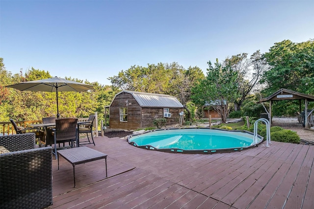 view of pool with a wooden deck and an outdoor structure