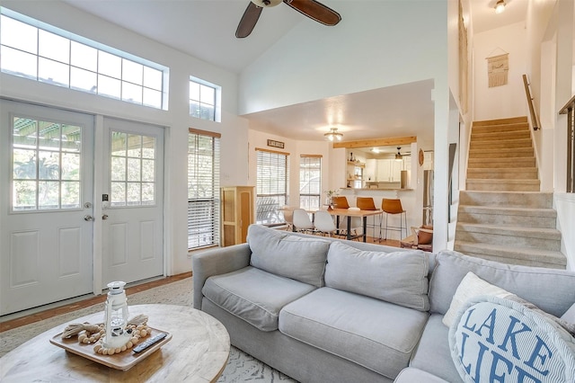 living room featuring high vaulted ceiling, ceiling fan, and light hardwood / wood-style flooring