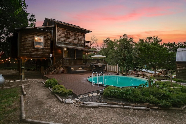 pool at dusk featuring a deck