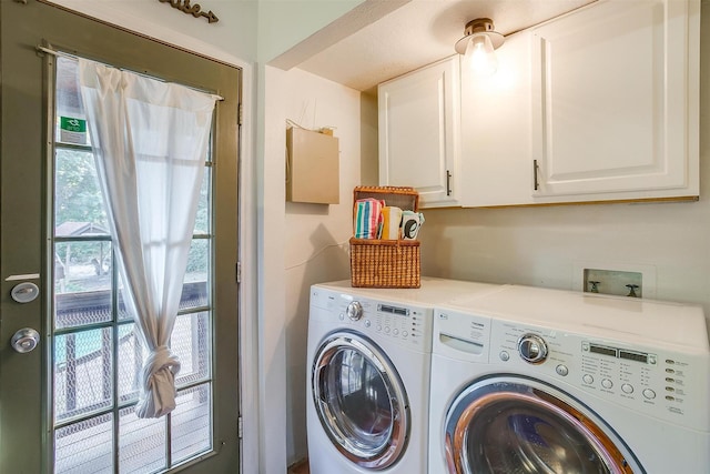 washroom with cabinets and washing machine and clothes dryer