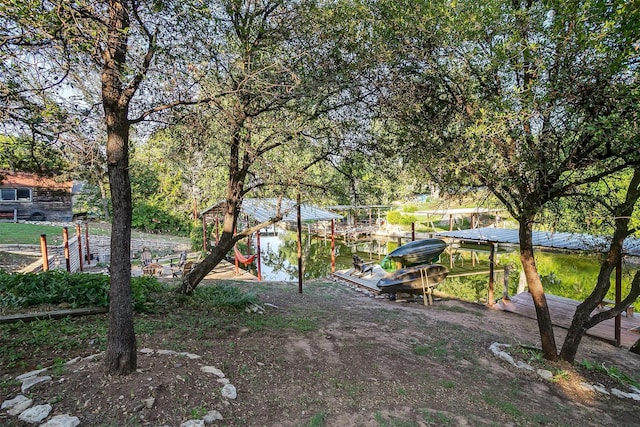 view of yard featuring a boat dock and a water view