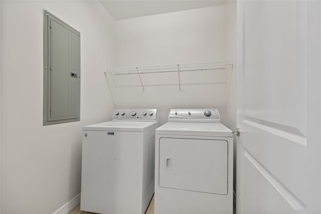 clothes washing area with washer and clothes dryer and electric panel