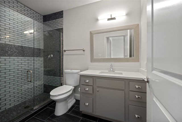 bathroom featuring vanity, toilet, a shower with door, and tile patterned floors