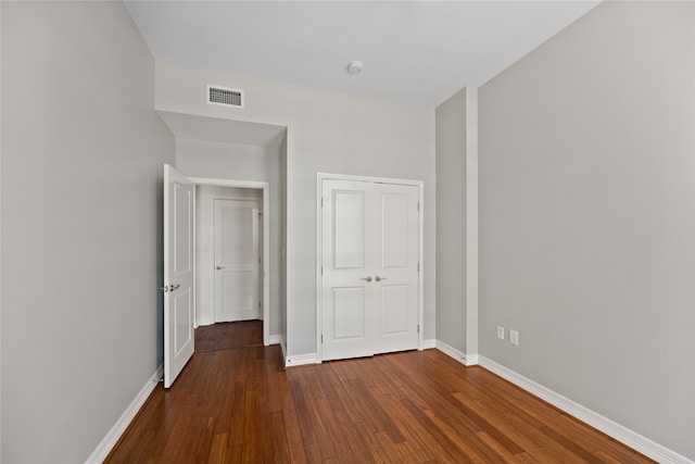 unfurnished bedroom with hardwood / wood-style flooring and a closet