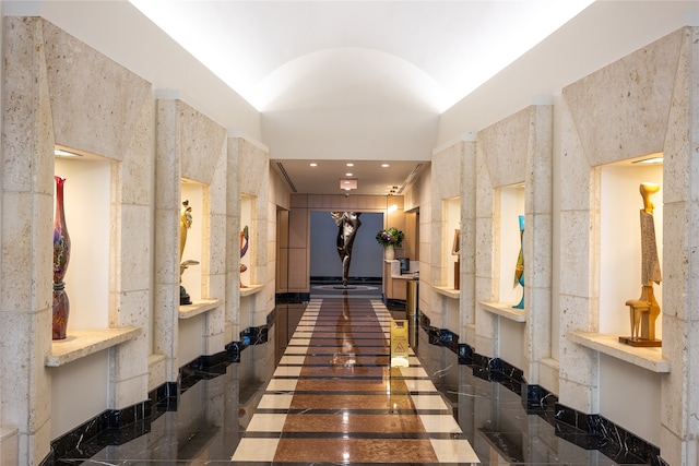 hallway with tile walls and dark tile patterned flooring