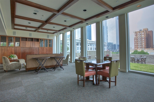 carpeted dining area with beamed ceiling, a wall of windows, and coffered ceiling