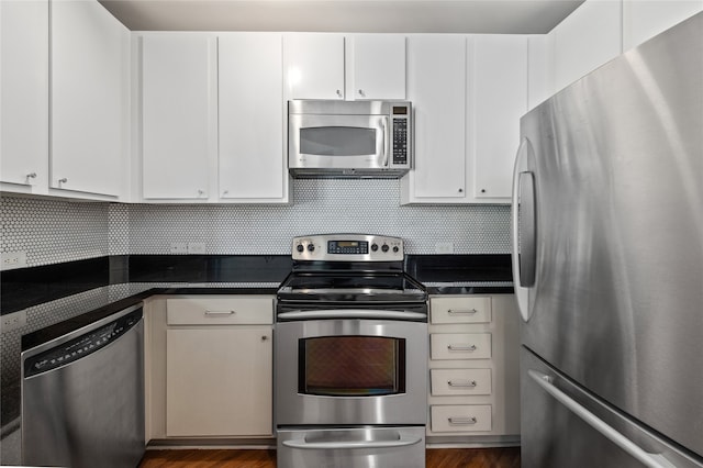 kitchen with white cabinets, tasteful backsplash, dark hardwood / wood-style flooring, and appliances with stainless steel finishes