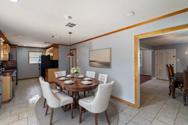 tiled dining room featuring ornamental molding