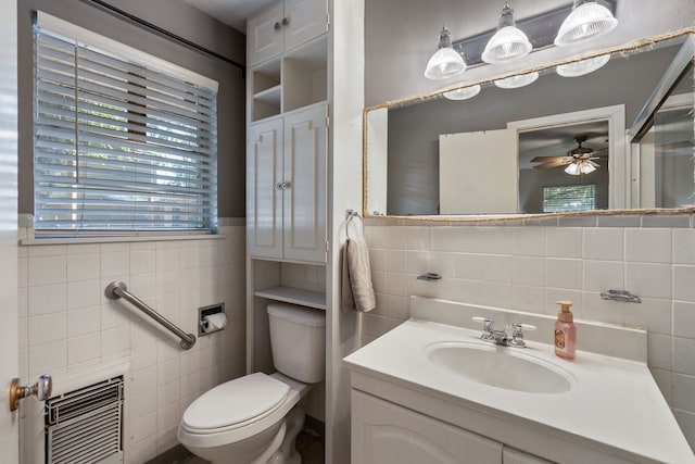 bathroom featuring toilet, vanity, tasteful backsplash, ceiling fan, and tile walls