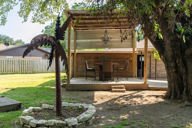 back of property with a pergola, a wooden deck, and a lawn