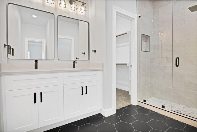 bathroom featuring walk in shower, tile patterned floors, and vanity