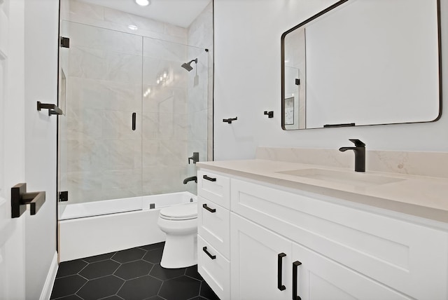 full bathroom featuring vanity, toilet, tile patterned floors, and combined bath / shower with glass door