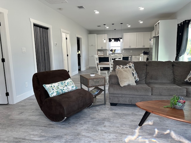 living room featuring light wood-type flooring and a wealth of natural light