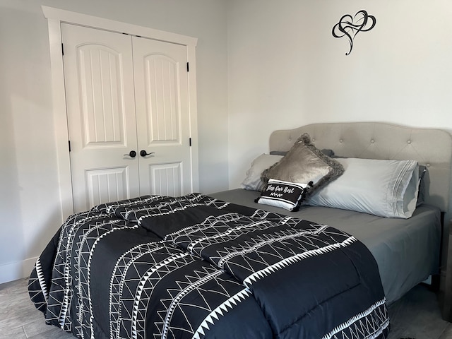 bedroom with wood-type flooring and a closet