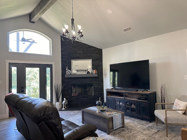 living room with light wood-type flooring, ceiling fan with notable chandelier, high vaulted ceiling, beamed ceiling, and a fireplace