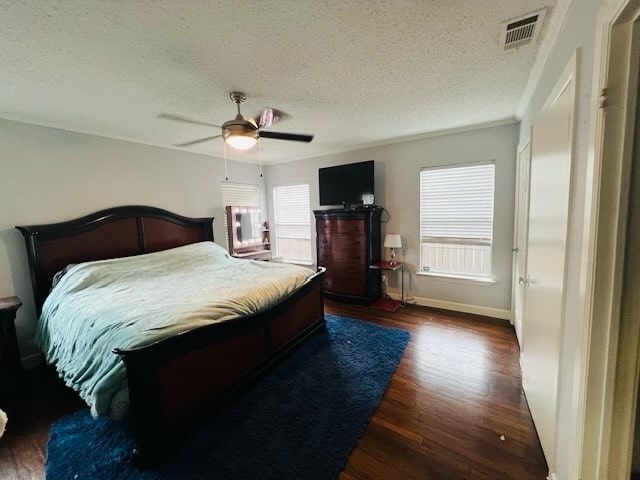 bedroom featuring dark wood-type flooring, a textured ceiling, and ceiling fan