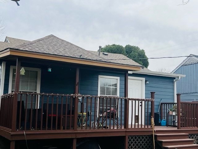 rear view of house featuring a wooden deck