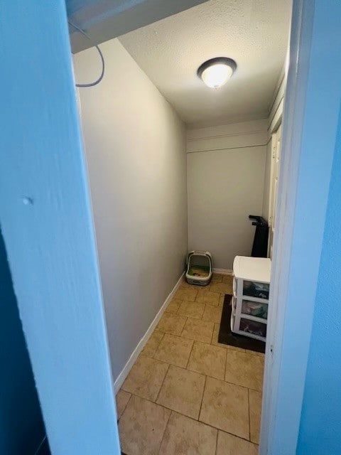 laundry room with light tile patterned flooring and a textured ceiling