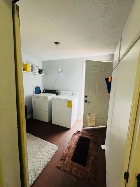 laundry area featuring dark hardwood / wood-style flooring, washer and clothes dryer, and a textured ceiling