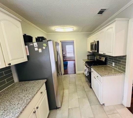 kitchen featuring decorative backsplash, stainless steel appliances, ornamental molding, and light tile patterned floors