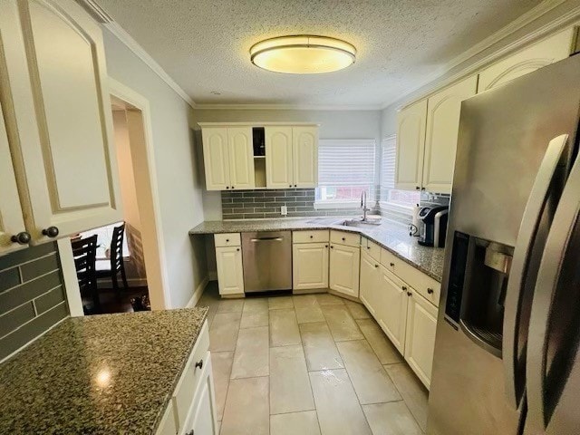 kitchen featuring decorative backsplash, crown molding, sink, appliances with stainless steel finishes, and a textured ceiling