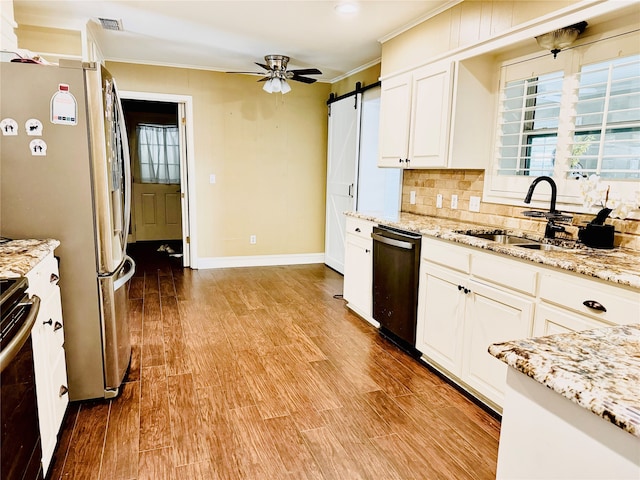 kitchen featuring a barn door, dishwasher, wood-type flooring, and crown molding