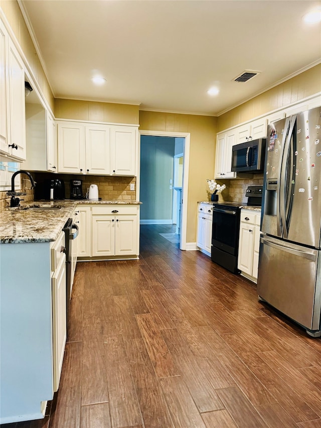 kitchen featuring appliances with stainless steel finishes, dark wood-type flooring, and white cabinets