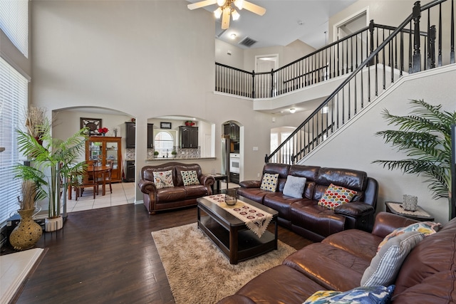 living room with ceiling fan, a high ceiling, and hardwood / wood-style flooring