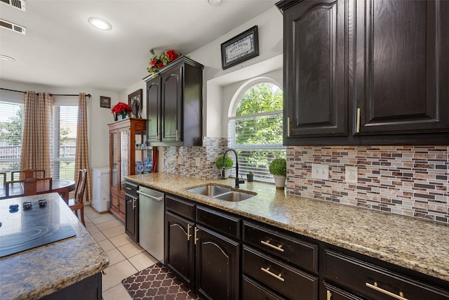 kitchen with decorative backsplash, dishwasher, light stone countertops, light tile patterned floors, and sink