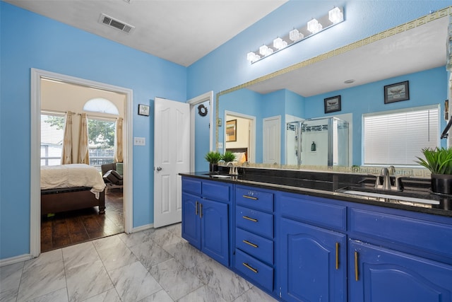 bathroom with double vanity, tile patterned floors, and an enclosed shower