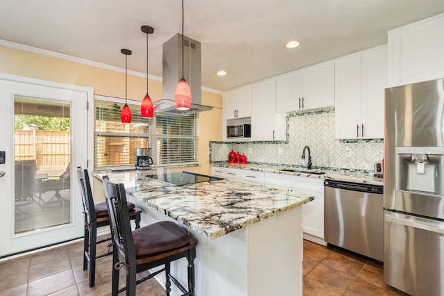 kitchen with white cabinets, decorative light fixtures, island range hood, a kitchen island, and appliances with stainless steel finishes