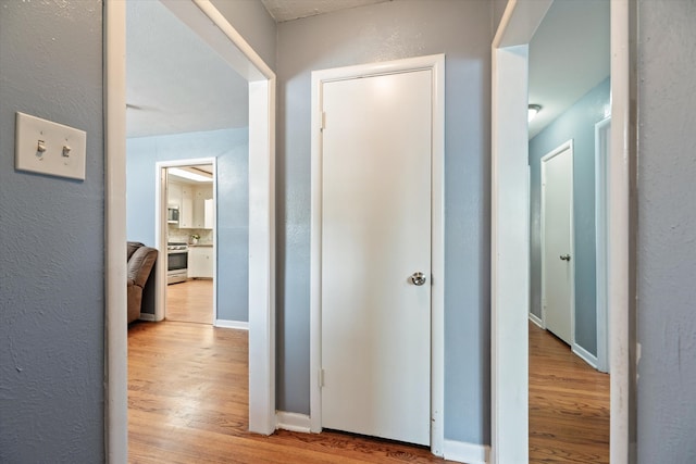 corridor with light wood-type flooring