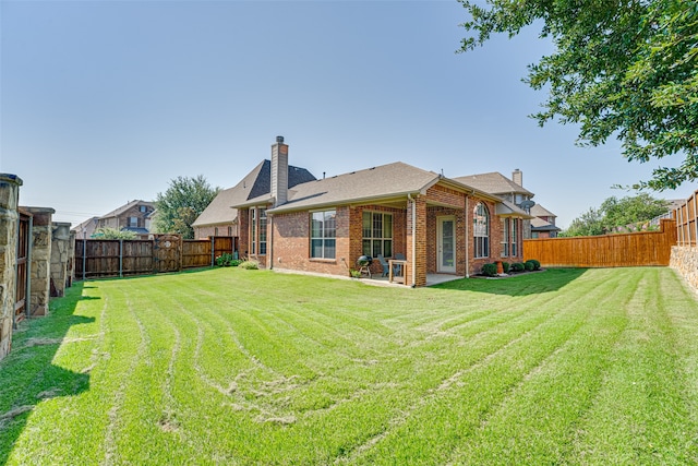 rear view of house with a patio and a lawn