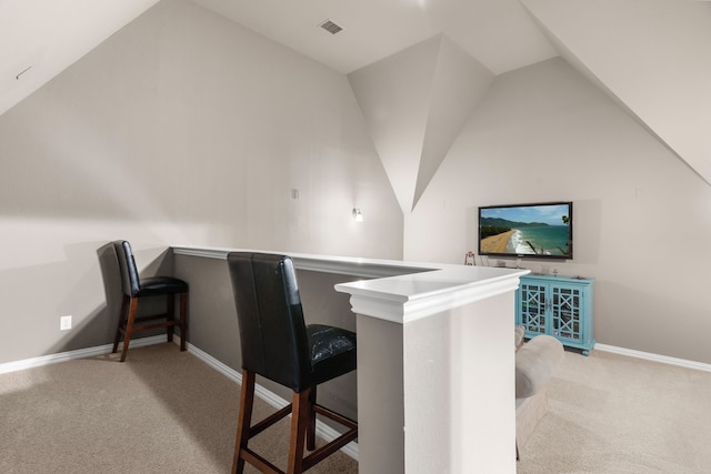 home office with light colored carpet and vaulted ceiling