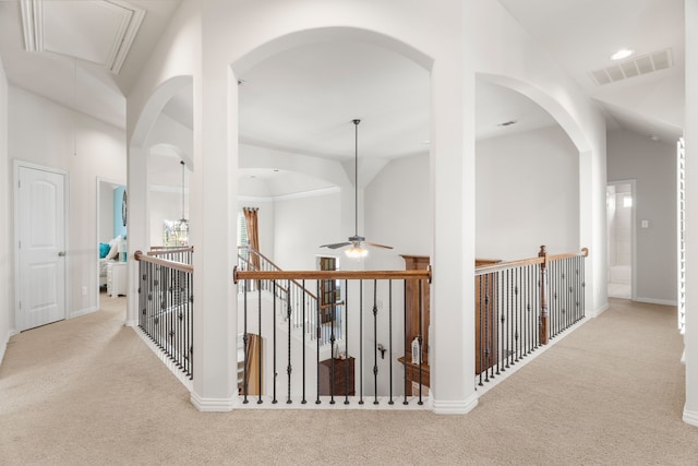 hallway featuring light carpet and vaulted ceiling