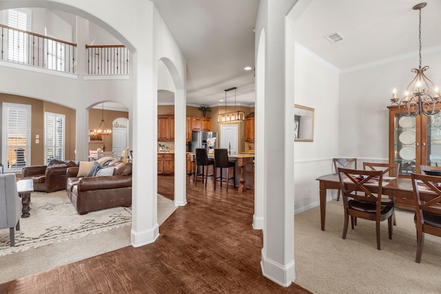 interior space with a notable chandelier, ornamental molding, and a high ceiling