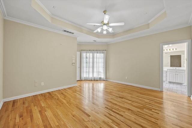 unfurnished room featuring crown molding and a tray ceiling