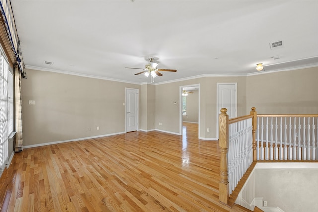 spare room featuring ornamental molding, ceiling fan, and light wood-type flooring